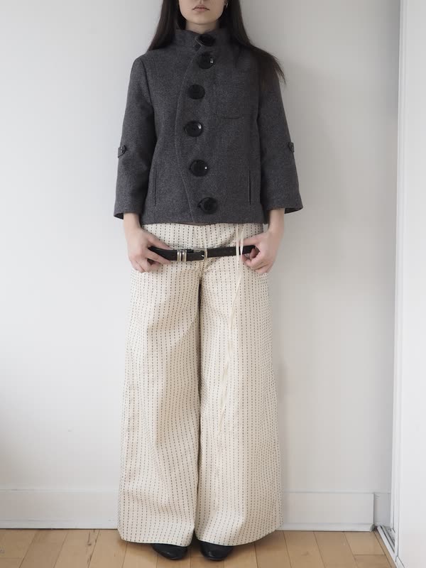Look four — black wool capelet over a corseted cream bodice and denim culottes.